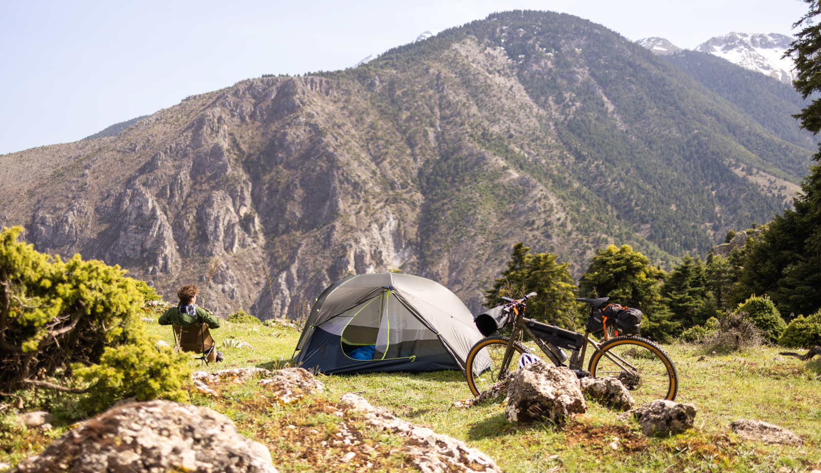 Man relaxing near his tent and bike