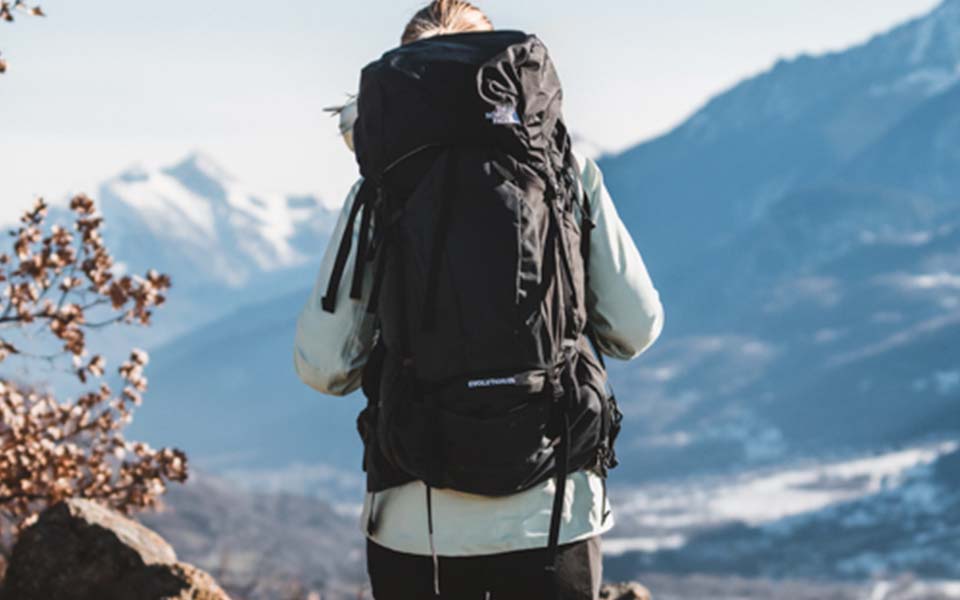 woman standing wearing The North Face backpack