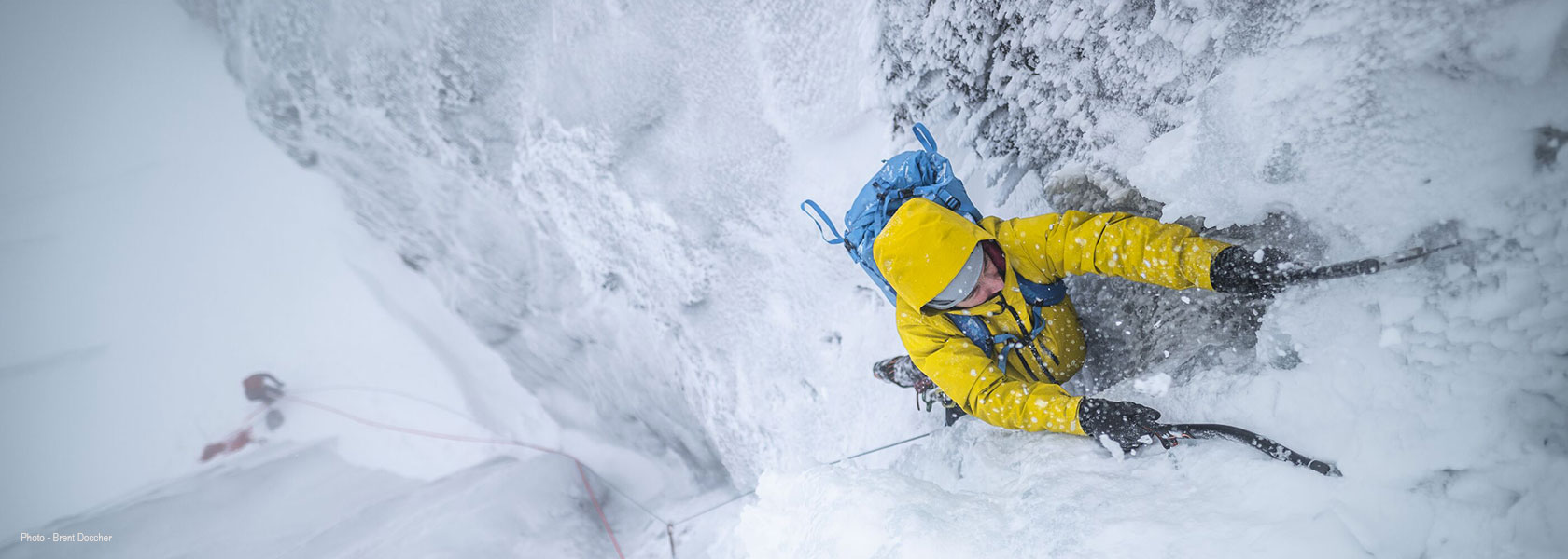 A person is mountaineering on a snow mountain, wearing Patagonia kit.