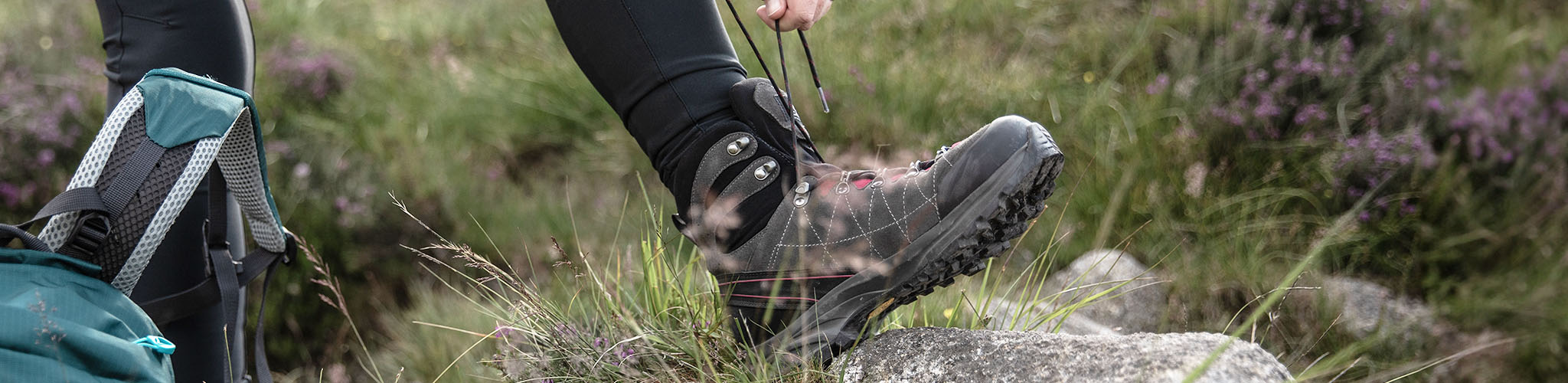 A person tying up the laces of their walking boots 