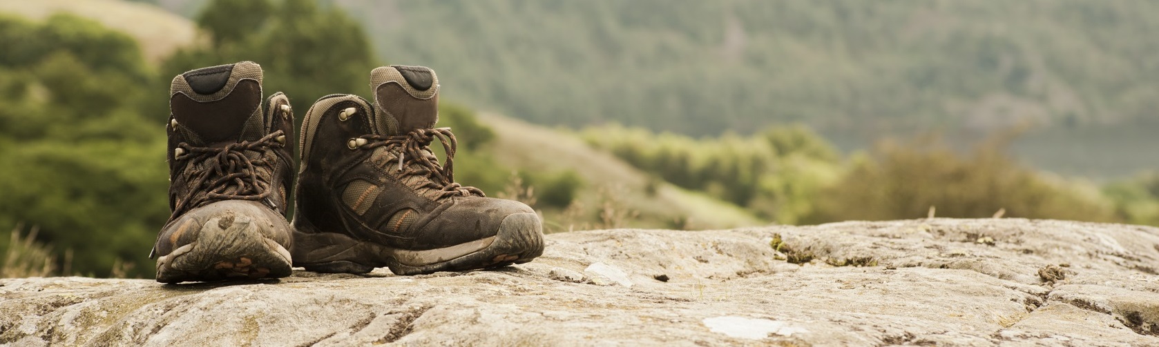 An image of walking boots on a rocky mountain path