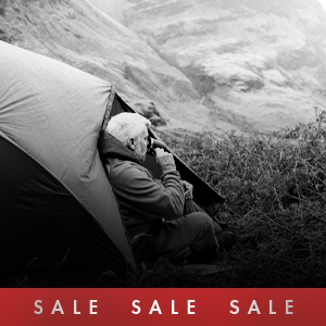 Shop camping sale. A man sitting in the entrance to a tent