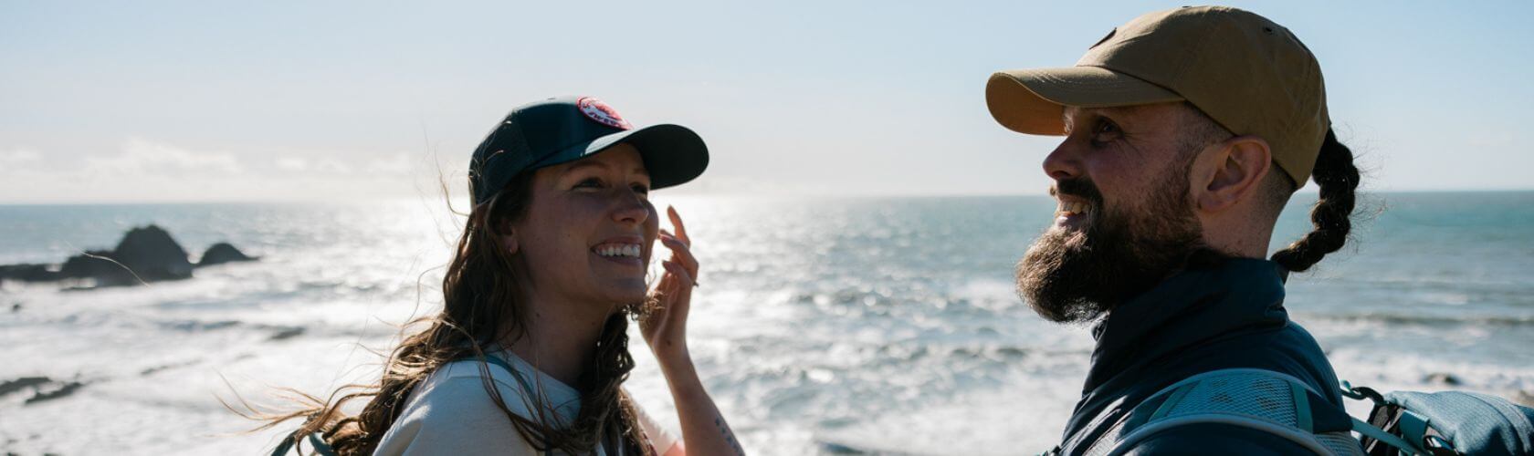 Inwanderment, steffan and emma laugh with the ocean in the background 