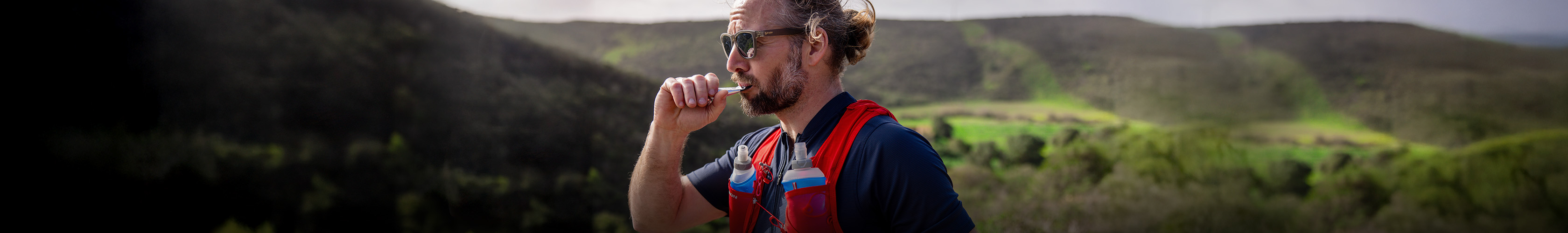 Shop Nutrition & hydration. A man on a trail run enjoying his liquid pouch