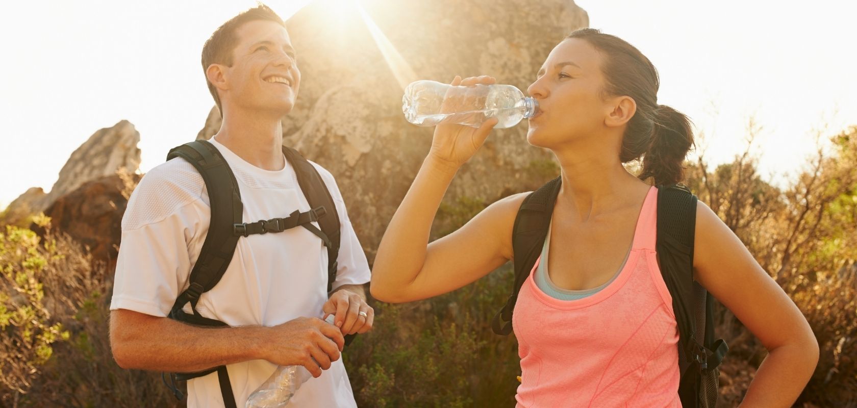 Two people hydrating on a hike