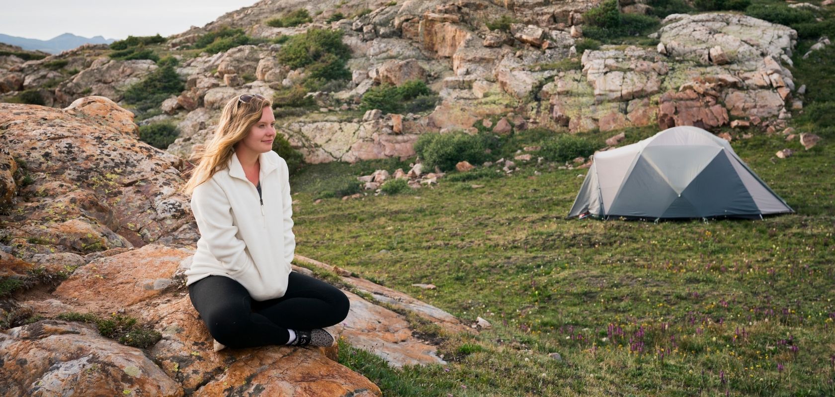 A woman wearing a fleece on a camping trip