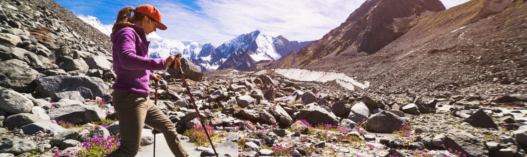A woman wearing a fleece on a hike over rocky terrain