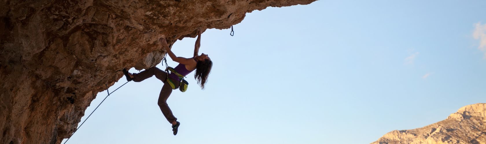 A person rock climbing up a rock face 
