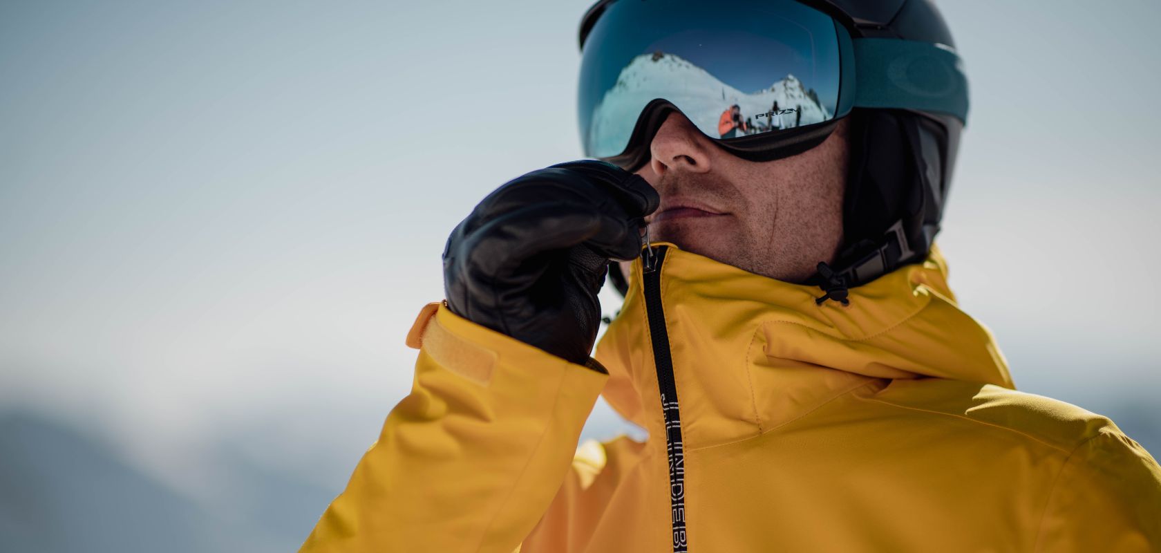 A man wearing a yellow ski jacket 