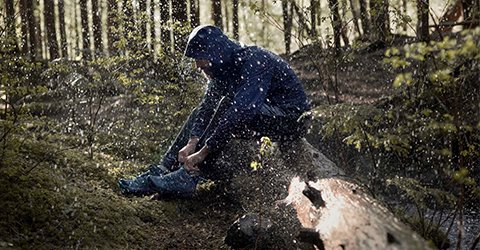 Person's feet in GORE-TEX boots, walking on a fallen tree.