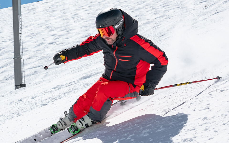 A man wearing Spyder ski clothing skiing down the piste 