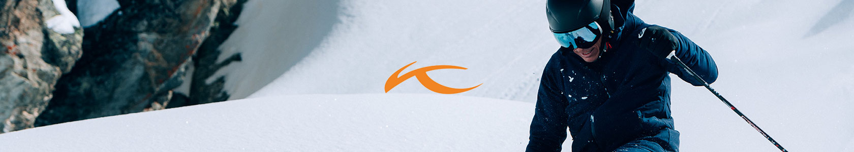 Kjus header image. The Kjus logo over an image of a man skiing