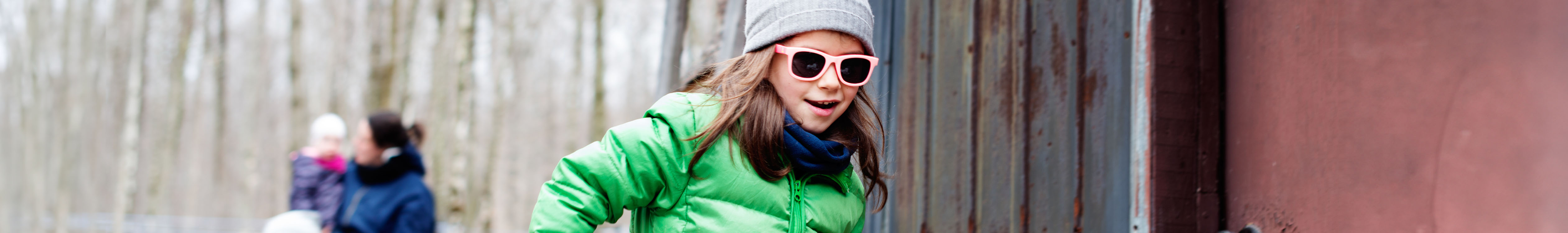 Shop kid's accessories. A girl wearing winter hat and sunglasses