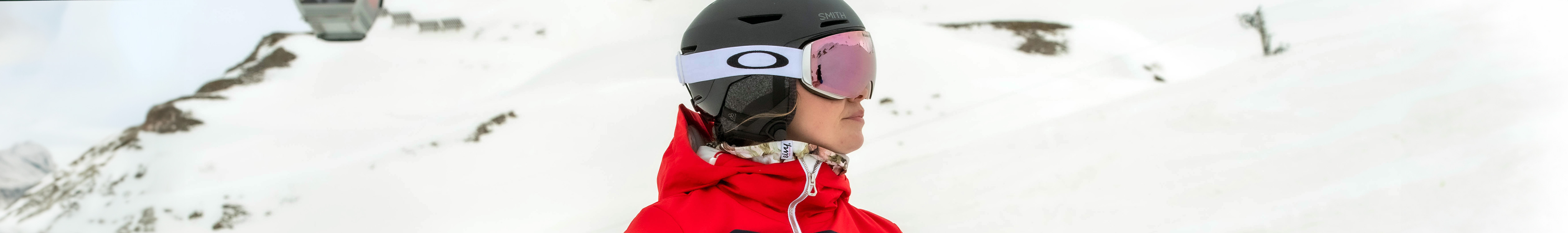 Shop ski helmets. A woman wearing black ski helmet and goggles