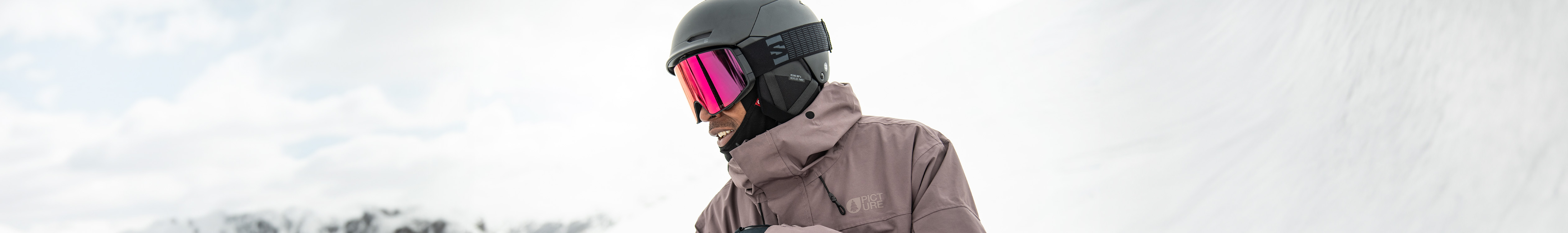 Shop helmets. A man wearing a helmet on a snowy mountain 