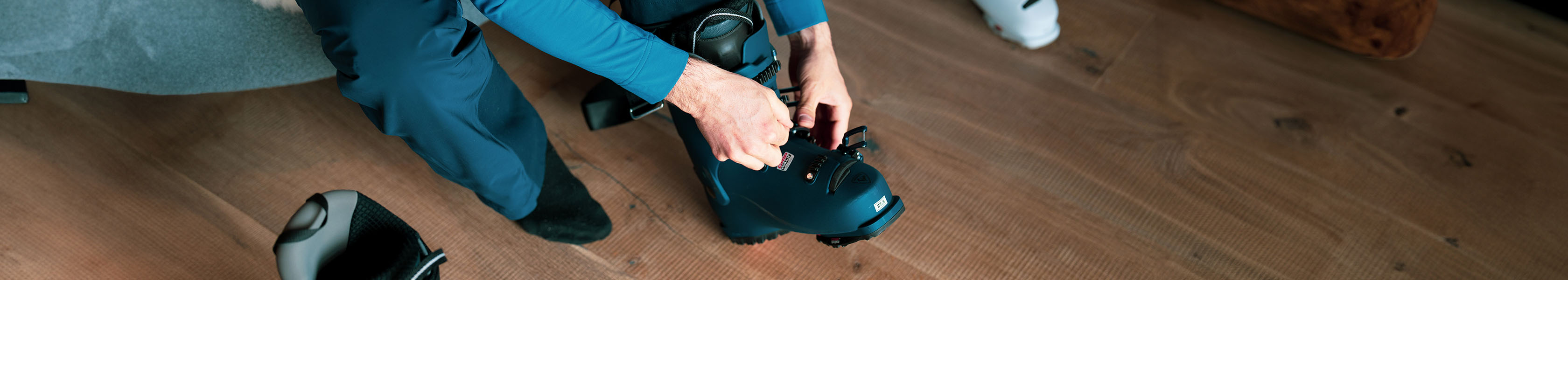 Ski boot fitting service. A person being fit with a pair of ski boots in store.
