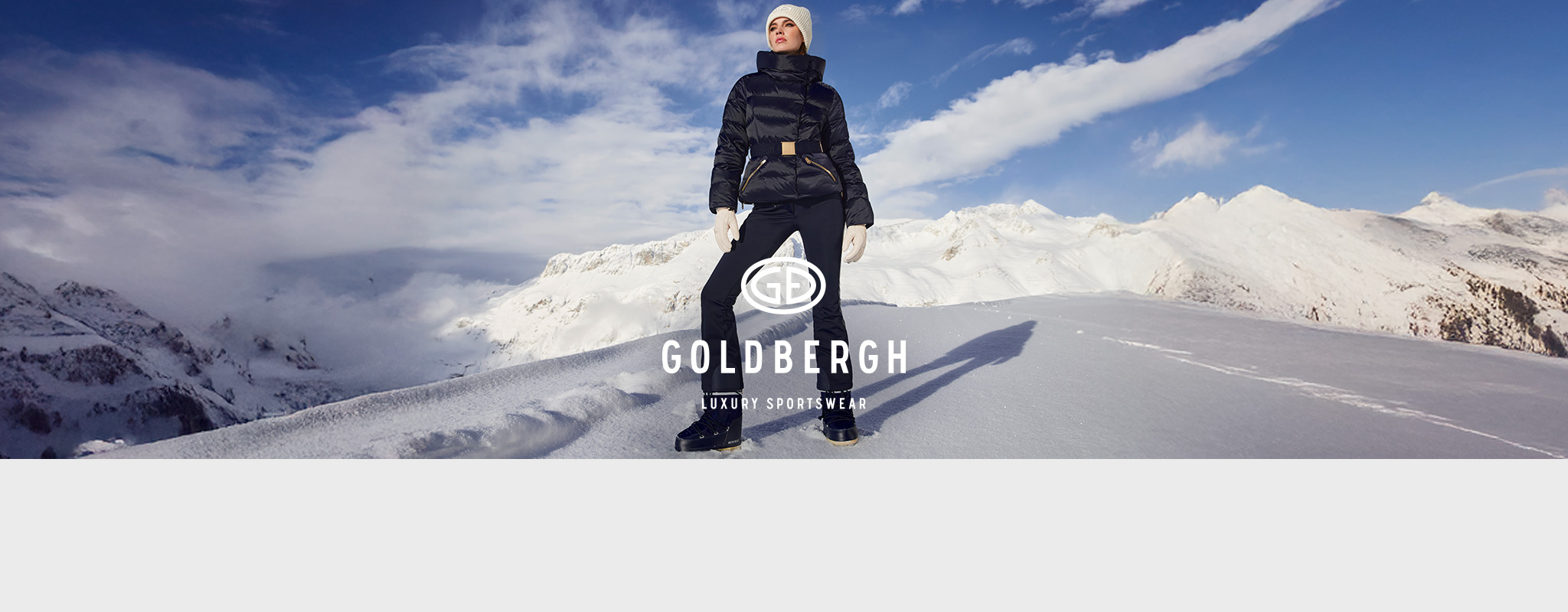 Shop Goldbergh collection. A woman in Golbergh clothing standing on a snowy mountain 