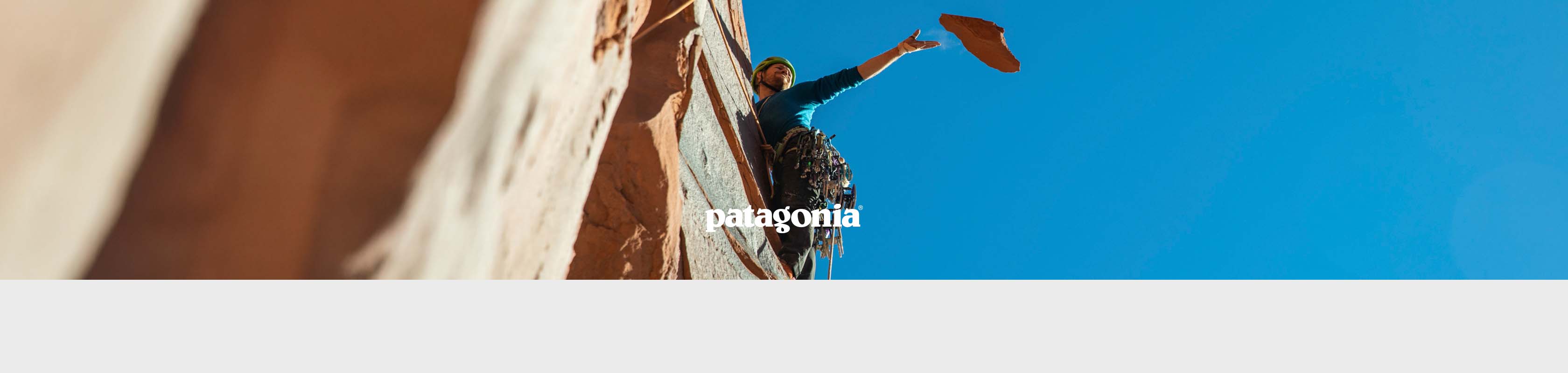 Shop Patagonia collection. A man climbing a rock