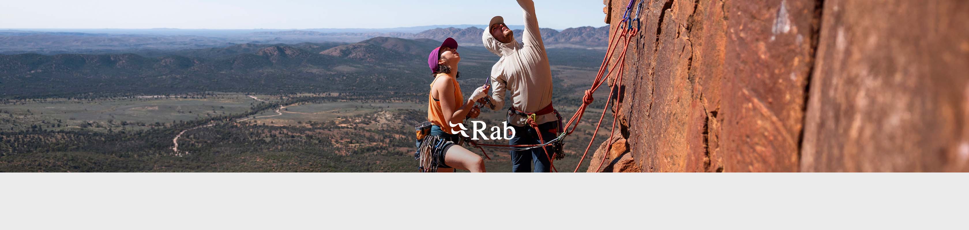 Shop Rab collection. Two climbers on a side of a rock