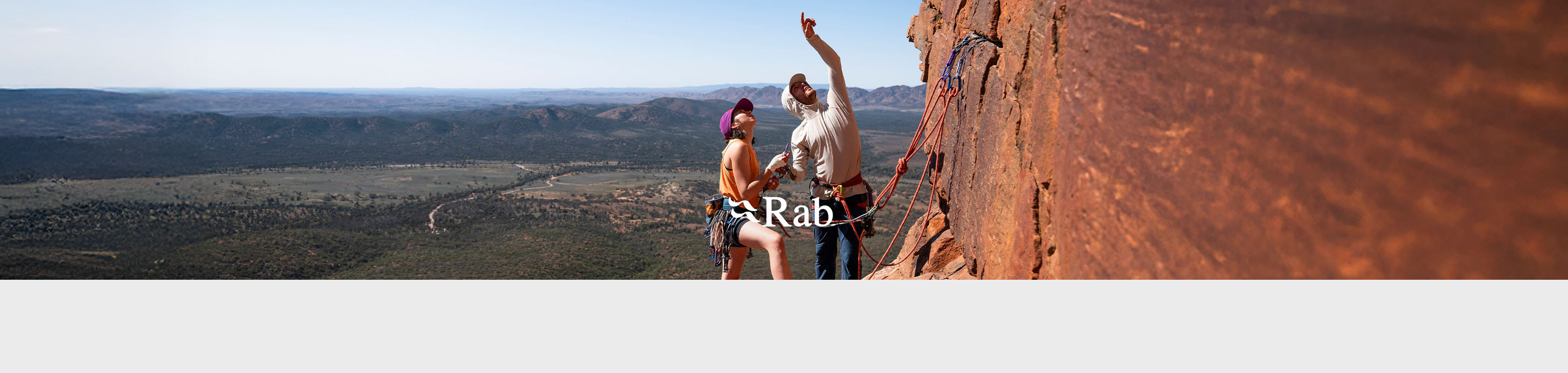 Shop Rab collection. Two climbers on a side of a rock