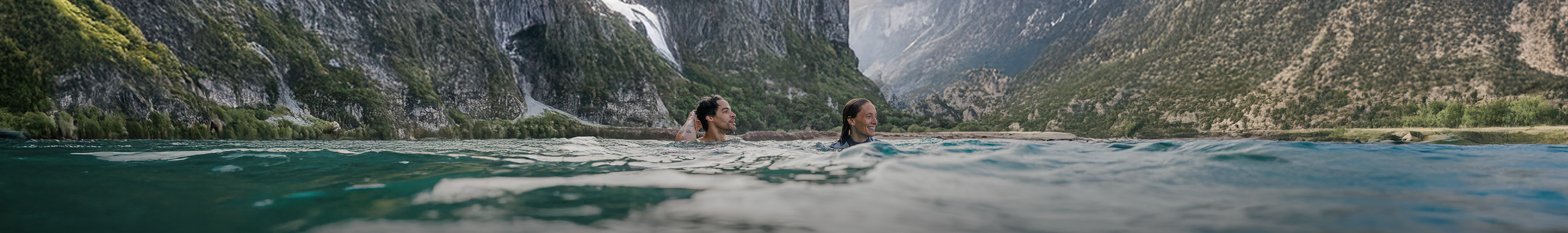 Shop Wild swimming new season on Snow + Rock. Two people swimming in a lake 