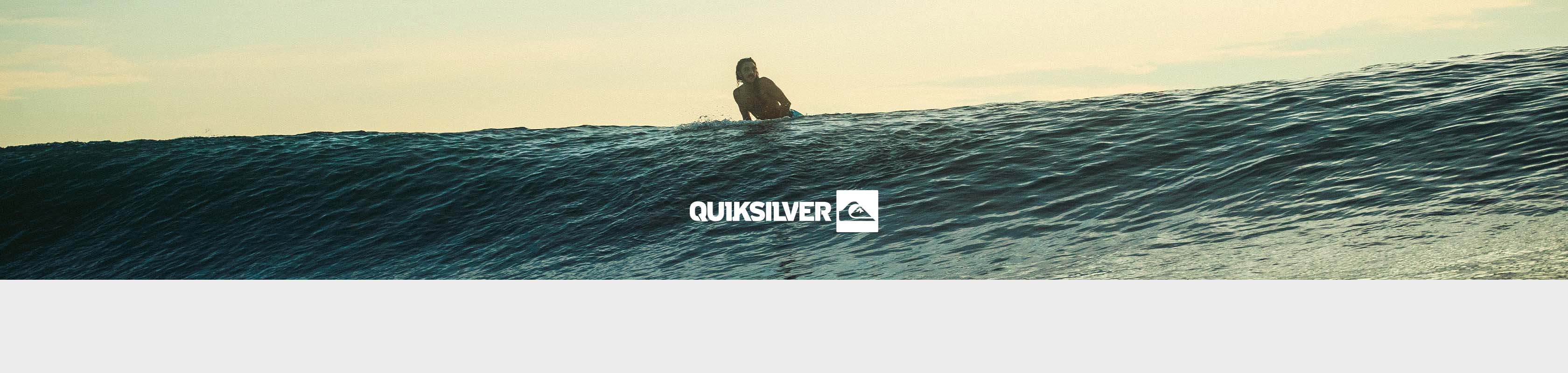 Shop Quicksilver clothing collection. A man surfing in the ocean