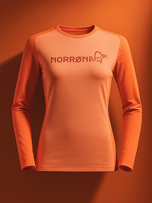 Shop ski thermals and base layers. A peach ski jbase layer top on peach background