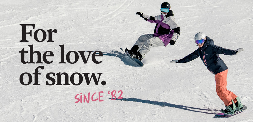 Shop snowboard new season. Two people snowboarding down the mountain