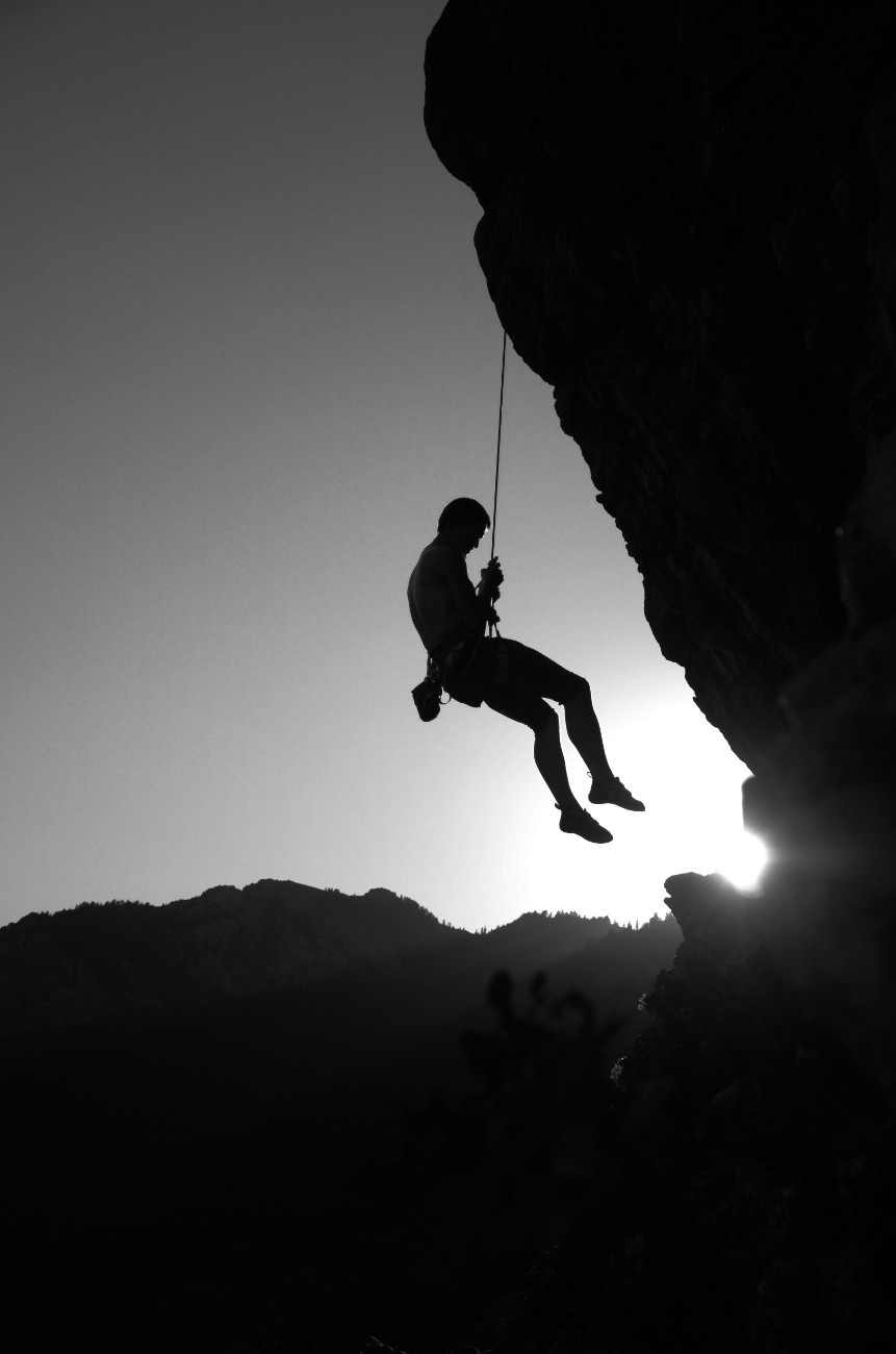 A person hanging by their harness off a cliff edge 
