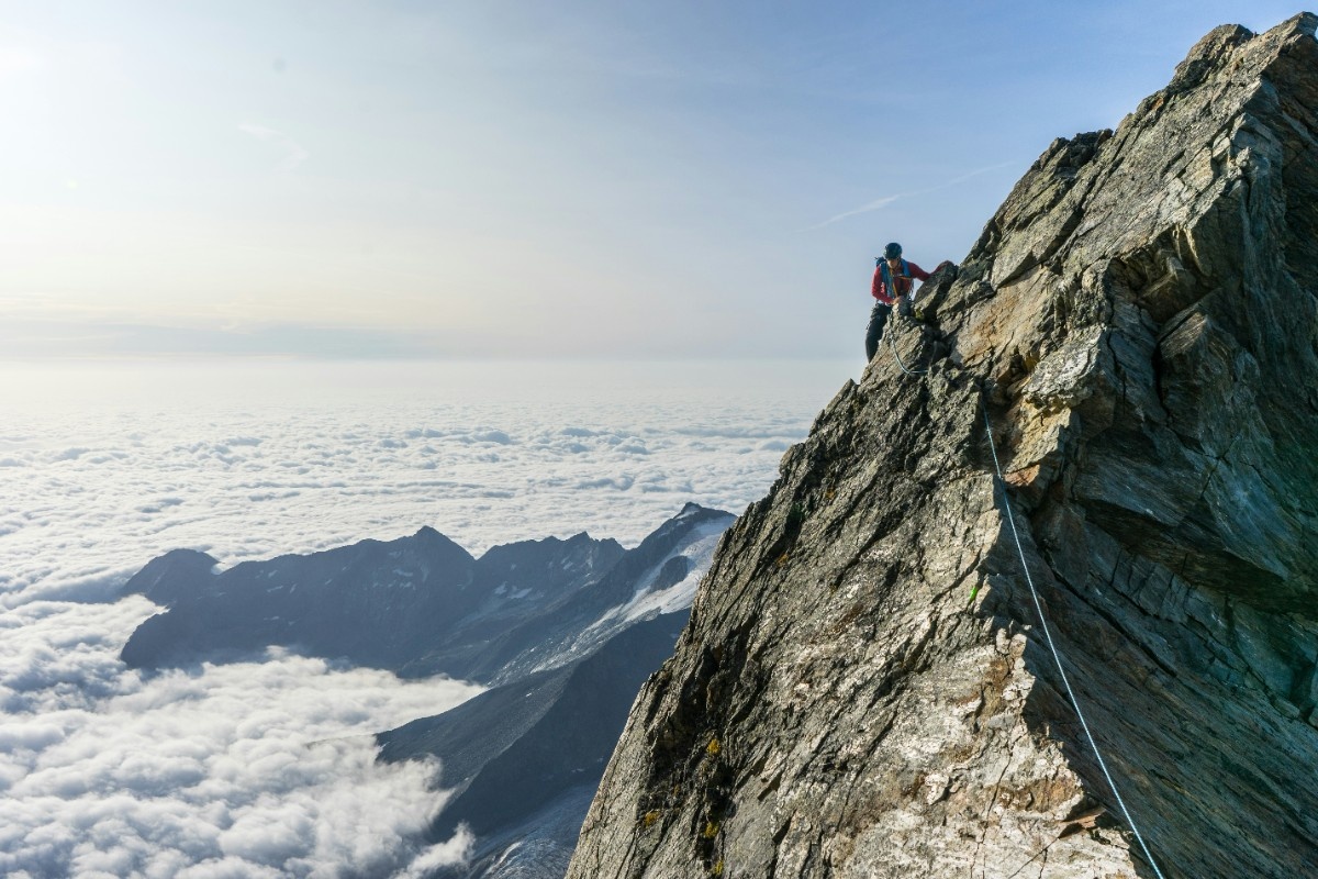 A person climbing above the clouds
