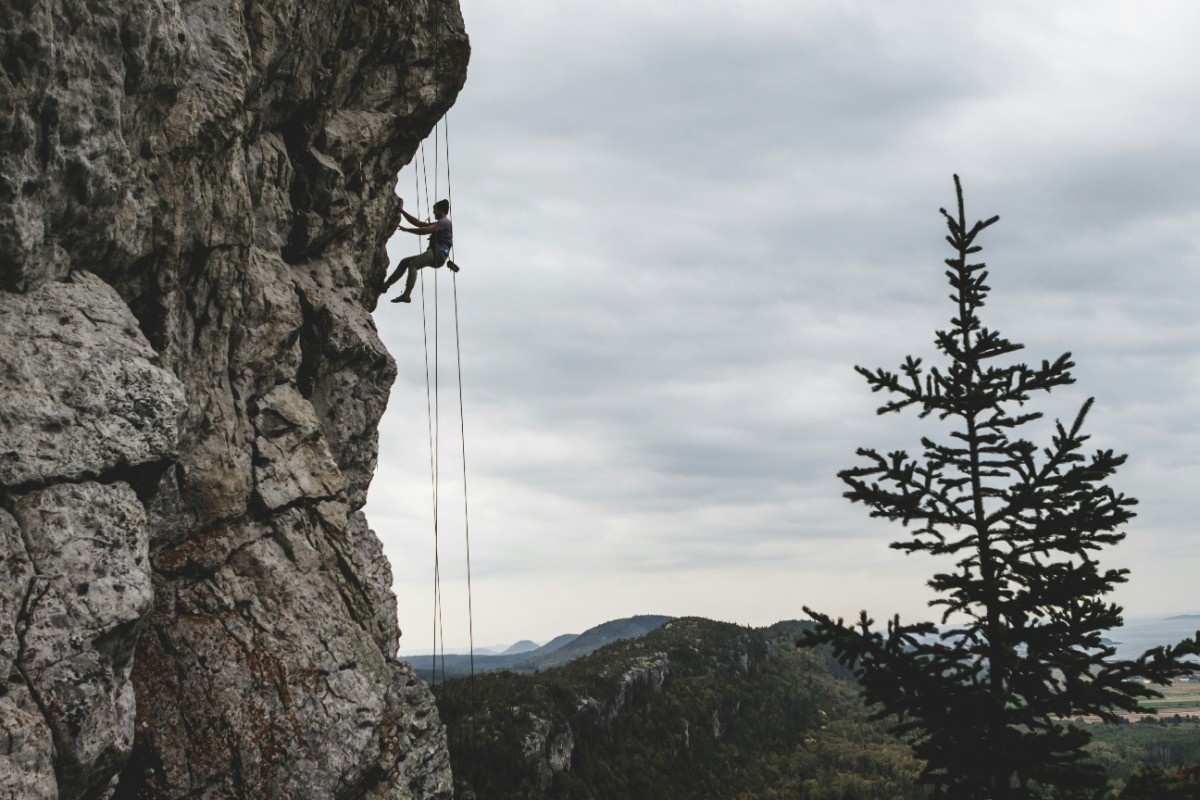 A person scaling a rocky cliff face