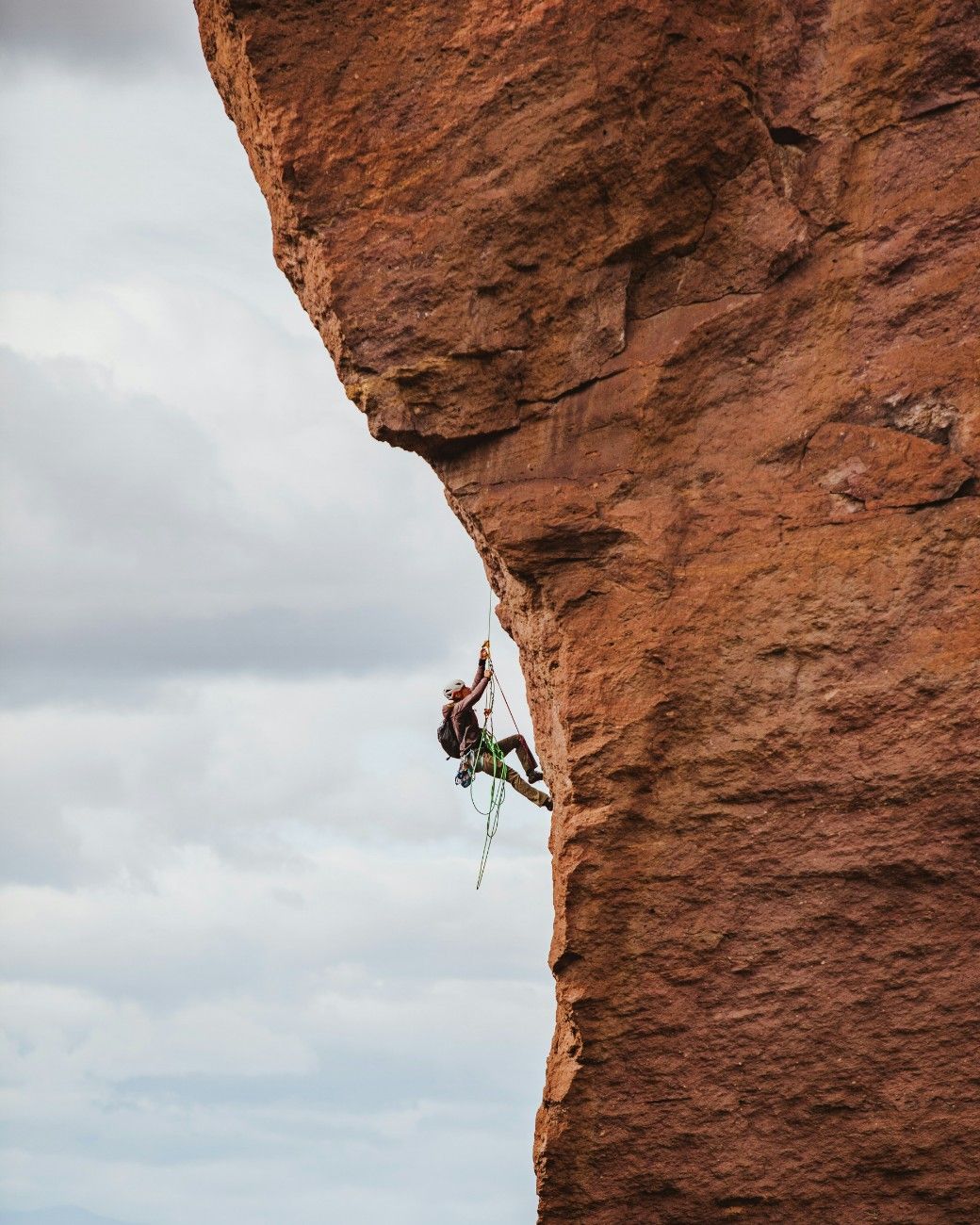 A person climbing a rocky cliff face