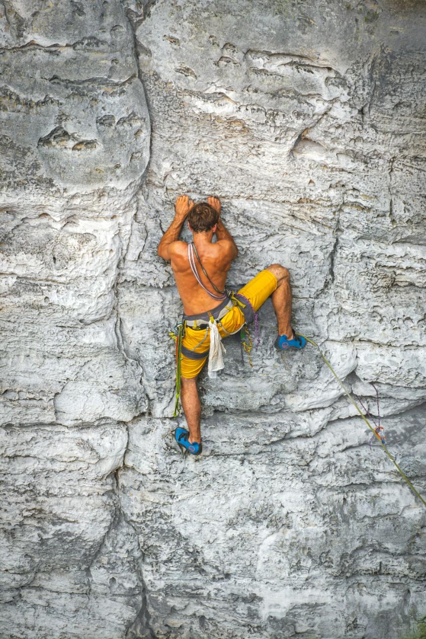 A person scaling a rocky cliff face