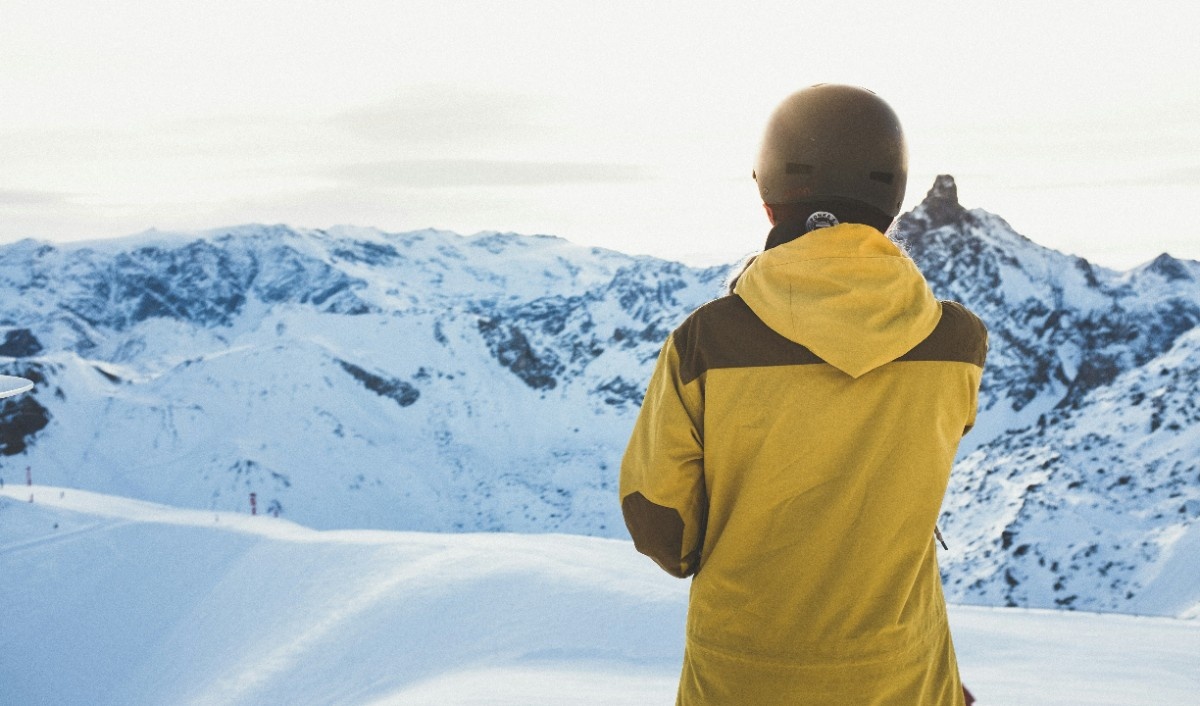 A man in a yellow ski jacket looking out at Méribel Ski Resort